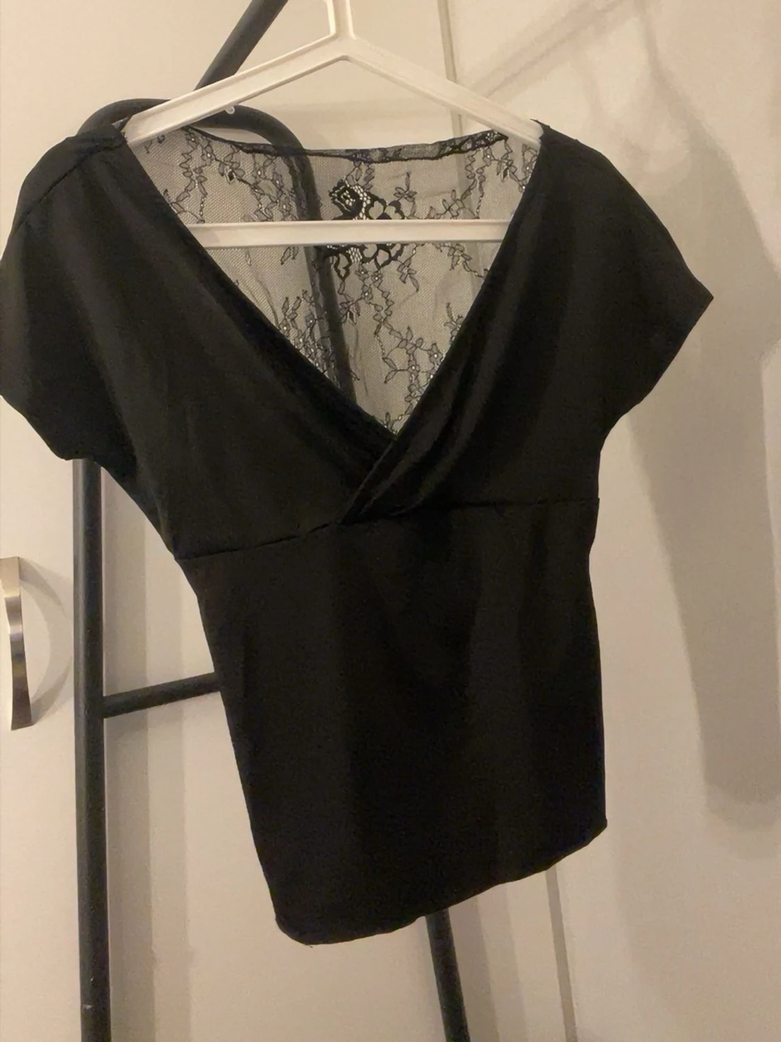 Svart omlottopp med spetsdetalj