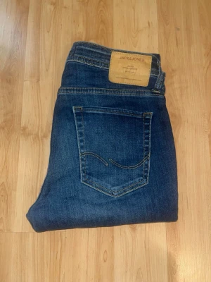 Jack & Jones jeans  - Mörkblåa skinny jeans från Jack & Jones, modell skinny / Liam. Midja 38cm, längd 114cm. JAG SKICKAR EJ FLER BILDER NÄR JAG BÄR JEANSEN! för bättre inblick i passformen rekommenderar jag att googla på modellnamnet. För storleksguide kolla måtten noggrant då jeansen alltid kan vara uppsydda heller krympta och jag ej tar emot returer :) 