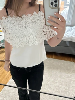 Vit axelbandslös topp med spets - Söt axelbandslös topp med blommig spetsdetalj över bysten. Tyvärr står inte storleken men skulle tro att det är s 💕💕