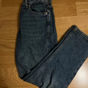 Jack & Jones Regular Clark jeans blå - Snygga blå jeans från Jack & Jones, modell Regular Clark. Klassisk femficksdesign med raka ben och normal passform. Jeansen har tydliga kontrastsömmar och en läderpatch med logga bak i midjan. Perfekta för dig som gillar en enkel och tidlös stil.