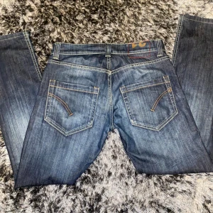 Mörkblå dondup jeans - Säljer ett par mörkblåa dondup jeans i storlek 31 i lite rakare modell men fortfarande slimfit. De är i bra skick men läder patchen på insidan är sprucken men de syns inte utifrån. Midja ca 42, längd ca 98 hör av er vid fler bilder eller frågor!😀