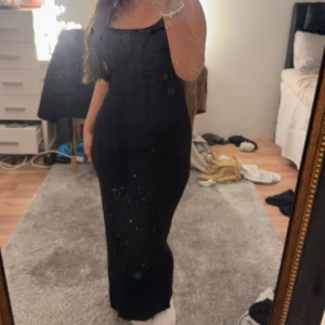 Svart långklänning med smala axelband - Säljer en svart långklänning med smala axelband och figurnära passform. Klänningen har en enkel och stilren design som framhäver siluetten. Materialet är mjukt och stretchigt, vilket gör den bekväm att bära. Perfekt för dig som gillar minimalistisk och elegant stil.