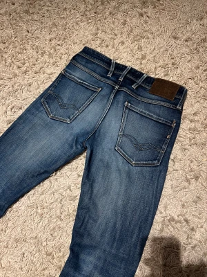 Replay anbass jeans  herr slim fit w31 herr blå - Replay anbass  jeans i slim passform. Mycket bra skick, inga märkvärdiga defekter. Storlek W31, med snygga slitningar vid hälen. Skön wash på dessa, postas samma dag som köp eller dagen därpå🙌💯