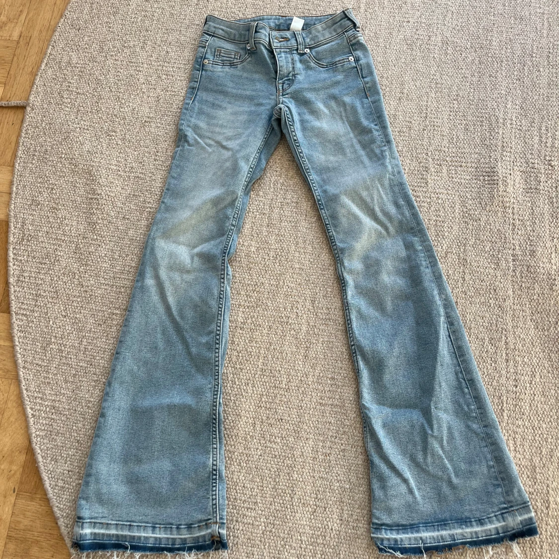 Ljusblå bootcut jeans med slitna kanter