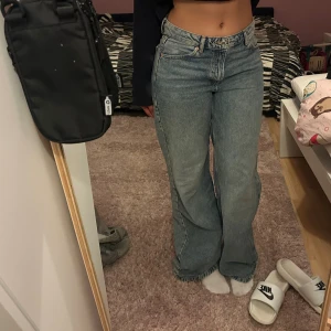 Blå jeans  - Säljer ett par klassiska Levi's 501 jeans i ljusblå tvätt. De har hög midja och raka, vida ben för en chill och trendig look. Jeansen är i 100% bomull och har fem fickor samt knappgylf. Perfekta för dig som gillar vintagevibbar och loose fit.