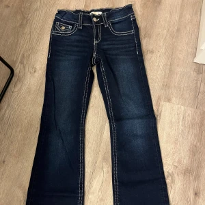Mörkblå jeans från Gina Tricot, stl 152 - Mörkblå jeans från Gina Tricot med kontrasterande vita sömmar och snygga fickdetaljer med knappar bak. Klassisk femficksmodell i stretchig denim, raka ben och normal passform. Perfekta för dig som gillar stilrena och tidlösa jeans. Lowwaist jeans. Dom  passar både till vardags men också till festliga tillfällen! Endast använt 1-2 så helt nya! Priset är inte fast. Kan skicka fler bilder vid intresse!💙💙