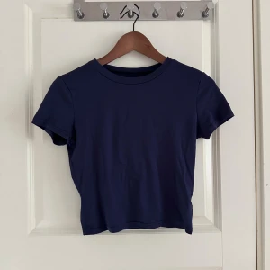 Mörkblå croppad t-shirt - En stilren mörkblå croppad t-shirt med rund halsringning och korta ärmar. Stretchigt material så passar även M💙