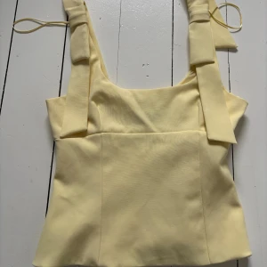 Gul linnetopp med rosett från Zara - Snygg gul topp med rosetter från Zara. Helt ny. 