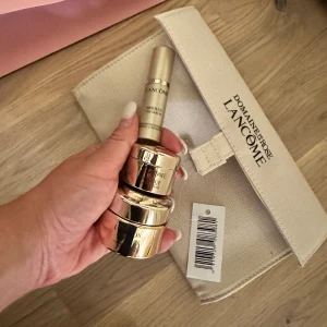 Lancome Absolue serum och ögonkräm - Lyxigt set från Lancome Absolue med ett intensivt serum och en ögonkräm i snygga guldfärgade förpackningar. Kommer med en beige necessär i tyg med tryckt logga. Perfekt för dig som vill boosta din hudvårdsrutin med exklusiva produkter.