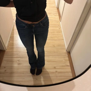 Blå bootcut jeans - Säljer ett par klassiska blå jeans med bootcut-modell och mid midja, 