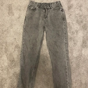Grå jeansbyxor från RYVLS - Säljer ett par grå jeansbyxor från RYVLS i storlek 158/164. Byxorna har klassisk femficksdesign, raka ben och normal passform. Perfekta för dig som gillar en enkel och stilren look. Materialet är slitstarkt denim i en snygg tvättad grå nyans.