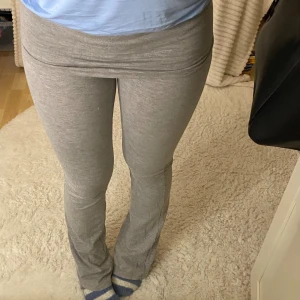Grå bootcut mjukisbyxor - Säljer ett par grå mjukisbyxor med bootcut och låg midja. Byxorna är i mjukt och stretchigt material, perfekta för chill dagar. De har en bred linning som kan vikas ner och sitter tight upptill med utsvängda ben.  Säljer pågrund av att de har blivit försmå💕 