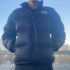 North Face Nuptse 700 - Säljer min otroligt snygga North Face Nuptse 700 1996 modell, passar till allt, justerbar midjeband/handleds-band, riktigt varm och skön. Perfekt nu till vintern/hösten. Jackan är i nyskick förutom en lite skeva på vänstra armen men det är bra ihop sytt. Fraktar så fort jag kan och nypris ligger på 3500-4000. 