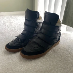 Isabel Marant svarta sneakers med kardborre - Säljer nu mina älskade Isabelle marant skor🫶🏻 så så fina och helt perfekta nu till hösten . Storlek 39 . Tecken på användning finns såklart som att texten är avskavd i sulan och det vita på dom är inte kritvit längre men inget större som hål eller så ❣️❣️ hör gärna av er vid frågor ☺️