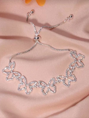 Armband glittrande fjäril  - Bilderna visar ett armband med fjärilar i silverfärg och strass, inte en väst. Kan ej ge beskrivning eller taxonomier för väst.