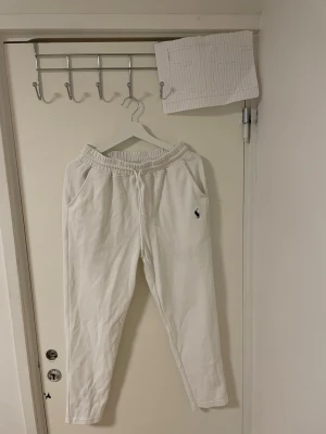 Vita mjukisbyxor  Polo Ralph Lauren - Säljer ett par fräscha vita mjukisbyxor från Polo Ralph Lauren i stretchig bomull. Byxorna har resår i midjan, sidofickor och en bakficka. Klassisk Polo-logga broderad på benet. Perfekta för chill dagar eller när du vill vara bekväm men ändå se snygg ut.Liknande modell som originala.
