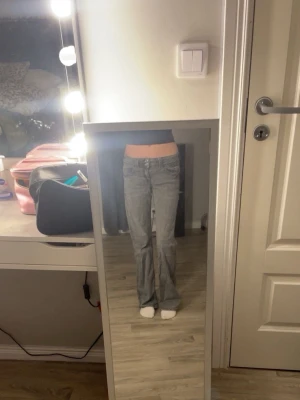 Grå jeans från Gina Tricot - Säljer ett par grå jeans från Gina Tricot i storlek 158. Modellen har låg midja och bootcut-ben, vilket ger en snygg siluett. Klassisk femficksdesign och tillverkade i jeansmaterial. Perfekta för dig som gillar en chill och trendig look.