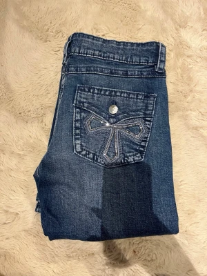 ALDRIG ANVÄNDA | Blå bootcut Low Waist jeans från Gina Tricot - *säljs ej längre + aldrig använda (förutom provade)* Snygga blå jeans från Gina Tricot i Low Waist bootcut-modell. Jeansen har klassisk femficksdesign och en cool bakficka med dekorativa paljetter i form av ett mönster. Materialet är jeans och passformen är normal. *säljer endast pga liiiite för korta - 173cm*