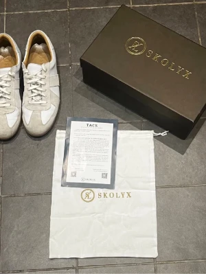 Skolyx GATS - Säljer ett par Skolyx Premium GAT-sneakers i storlek 44 EU, köpta i september i år. Skorna är i toppskick och allt tillbehör medföljer. Tillverkade i Portugal, i högkvalitativt full grain-läder. Perfekt för dig som vill sticka ut från det vanliga och samtidigt prioritera kvalitet.