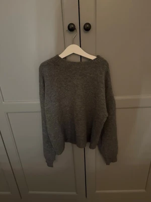 Grå stickad tröja från Mango - En enkel och snygg grå stickad tröja från MNG i storlek S. Tröjan har rund hals, långa ärmar och ribbade muddar vid hals, ärmslut och nederkant. Perfekt för dig som gillar en clean och chill stil under höst och vinter. Lite nopprig som beror på att den tvättats❤️