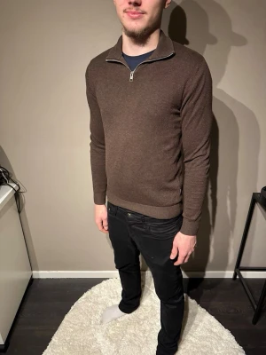 Brun half zip tröja Jack & Jones XS - Säljer en brun långärmad tröja från Jack & Jones i storlek XS men passar även M. Modellen är 178 o väger 75kg. Tröjan har en stilren half zip-dragkedja vid kragen och är tillverkad i ett mjukt stickat material. Perfekt för lager-på-lager och snygg till både jeans och chinos.