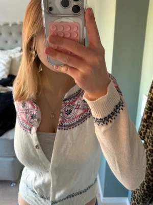 Vit kofta från Hampton Republic - Säljer en stickad kofta från Hampton Republic med snyggt mönster i rosa och mörkblått runt halsen och axlarna. Koftan har rund hals, knäppning framtill och långa ärmar. Perfekt för dig som gillar klassisk stil med färgglada detaljer. Hör av dig vid minsta intresse💕