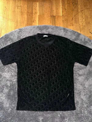 Dior T-shirt - Säljer en svart Dior T-shirt för ett bra pris! Den är storlek M men den är stor i storleken så den passar även dig som har storlek L. Tveka inte med att ställa frågor! Pris kan diskuteras.   *Inte äkta Dior*