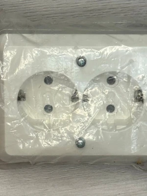 ABB Hörnbox 2-vägs uttag (IP21) - Hejsan!  Ett helt nytt och oöppnat 2-vägs vägguttag från ABB till salu. Detta är en praktisk hörnbox (Pistorasia) som är designad för smidig montering i hörn, perfekt för exempelvis kök under överskåpen eller vid skrivbordet.  Uttaget är jordat (Schuko) och utrustat med fjäderklämmor (snabbanslutning) för enkel och säker installation. Med sin IP21-klassning är den godkänd för fast montage inomhus.  Specifikationer:  • Märke: ABB OY (Finland)  • Typ: Hörnbox 2-vägs  • Egenskaper: Jordad, Schuko…