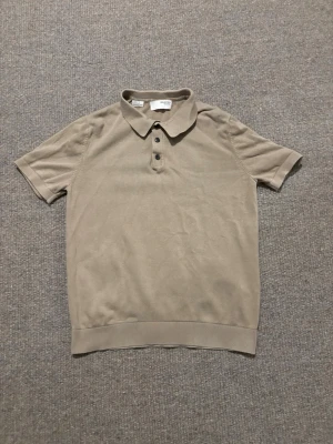 Beige kortärmad polotopp Selected Homme - Säljer en beige polotopp från Selected Homme i storlek M. Toppen har korta ärmar, klassisk krage och tre knappar framtill. Materialet är mjukt och känns som bomull, perfekt för vår och sommar. Stilren och enkel design som funkar till många outfits.