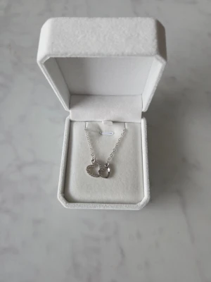 Halsband med hjärtan - Snyggt halsband med två ett är dekorerat med små glittrande stenar och det andra är slätt och blankt.