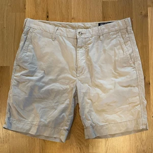 Snygga Beiga ChinosShorts Från Polo Ralph Lauren  - ✨ Polo Ralph Lauren Chinoshorts – Väldigt Bra Skick! ✨  📏 Storlek: 33 (M) 💰 Pris: 799 kr 🆕 Skick: Väldigt Bra Skick( Använd ett Fåtal gånger) Max 4 gånger!  Klassiska beige chinoshorts från Polo Ralph Lauren – perfekt för sommaren! Lätt att matcha, stilrena och bekväma för både vardag och fest.