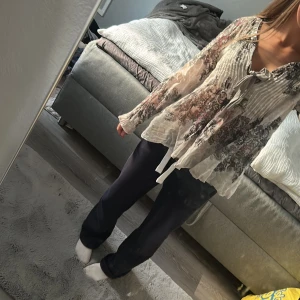 Mönstrad blus från Odd Molly, stl 0 - Supersöt blus från Odd Molly i tunn bomull med broderade detaljer och romantiskt mönster i beige, svart och rosa. Långärmad modell med knyt framtill och lätt v-ringning 💗