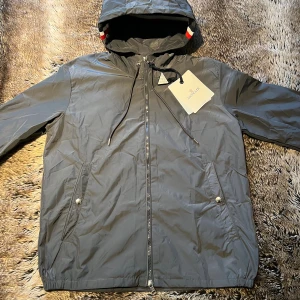Moncler Grimpeurs Vindjacka  - Säljer en helt ny äkta grå Vindjacka från Moncler i modellen Grimpeurs, original lapparna och äktighetstriangeln medföljer vid köp. Scan funkar och den är i Storlek 2/M,  perfekt nu för hösten. Hör av dig vid frågor eller intresse ✅
