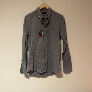 Grå skjorta från Morris Stockholm XS - Snygg grå skjorta från Morris Stockholm i storlek XS. Skjortan har button down-krage, diskret. Inte ett gnag av tidens tand syns då den bara legat i garderoben sen den köptes. Hör gärna av dig om du har fler frågor!
