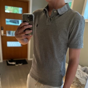 Grå Polo Ralph Lauren piké - |Tja! En otroligt snygg Ralph Lauren piké i en skön färg ❗️| Skick 9/10 otroligt bra skick☑️| Storlek: L , sitter som M/S, sitter bra på mig - 189cm 73kg📏| Nypris: ca 1500kr💵| Färg: grå, som på bilden🩶| Fraktar spårbart via postnord eller instabox📦| Hör av er för mer information!|