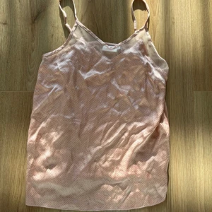 Prickig linnetopp från Coster Copenhagen - Söt ljusrosa linnetopp från Coster Copenhagen med små rosa prickar. Tunt och luftigt material, justerbara smala axelband och v-ringad hals. Perfekt för varma dagar när du vill ha en chill och stilren look.