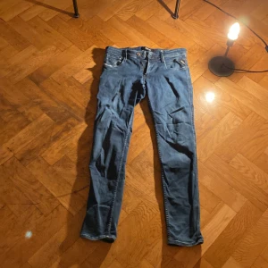 Blå Replay Anbass jeans herr - Säljer ett par snygga blå Replay Anbass jeans med klassisk femficksdesign och smal passform. Jeansen har normal midja, dragkedjegylf och är tillverkade i stretchig bomullsdenim för extra komfort. Perfekta för dig som gillar en modern och stilren look.