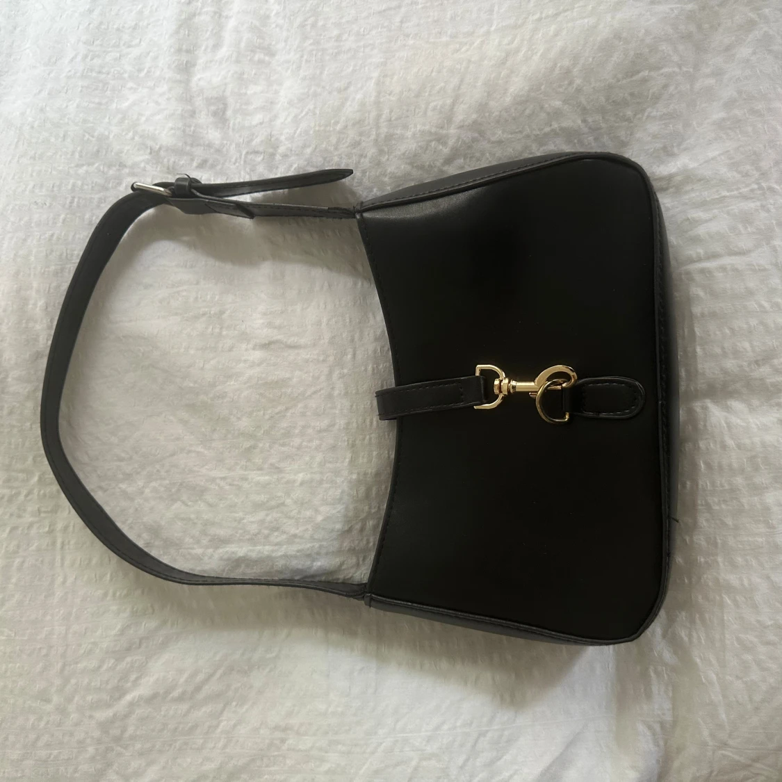 Svart axelväska med gulddetaljer