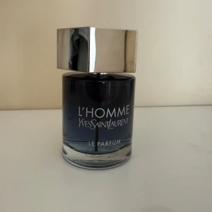 YSL L'Homme Le Parfum - YSL L'Homme Le Parfum i en stilren mörkblå glasflaska med silverfärgat, sexkantigt lock och YSL-logga på toppen. Flaskan har en modern, maskulin design som känns lyxig och tidlös. Flaskan är 100 ml men som ni ser har jag använt lite av den så det är kanske 80-85% kvar av vätskan.