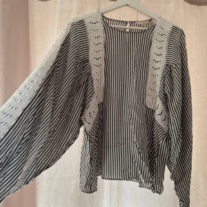 Randig blus med broderade detaljer H&M - Säljer denna svartvit randig blus från H&M i storlek M. Blusen har vida ärmar och snygga broderade partier i vitt längs axlar och sidor. Väldigt snygg men passar tyvärr inte längre💗
