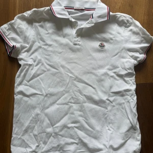 Vit Moncler pikétröja - Jävligt fräsch vit pikétröja från Moncler. Den är såklart äkta o pris är inte hugget i sten. Den är i topp skick, hade bara kanske behövts en strykning😅