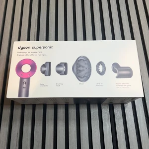 Dyson Supersonic - Dyson Supersonic hårfön i mycket fint skick, komplett med originalkartong och alla tillbehör: styling concentrator, smoothing nozzle, diffuser, gentle air attachment och flyaway attachment. Snabb torkning utan extrem värme, passar alla hårtyper. Inga synliga defekter eller slitage.