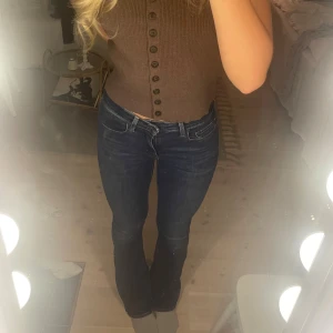 Levi's 725 Bootcut Jeans, mörkblå, stl 27 - Snygga Levi's 725 High Rise Bootcut jeans i mörkblå tvätt. Hög midja och klassisk bootcut-passform i storlek w27 L34, de sitter perfekt på mig som är 175cm lång. Har bara använt de ett fåtal gånger!