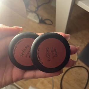 Isadora Perfect Blush Ginger Brown - Två stycken Isadora Perfect Blush i färgen 03 Ginger Brown. puderrouge i en varm brun-rosa nyans. rund dosa med spegel i locket, smidig att ha med i väskan. en har testats den andra är oanvänd.
