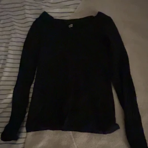 Svart långärmad tröja från 157 - En enkel svart långärmad tröja från märket 157 Tröjan har en klassisk rund hals och är gjord i ett mjukt material som passar perfekt till chill dagar. Stilren och lätt att matcha med dina favoritjeans eller sneakers.