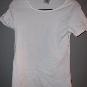 Vit basic t-shirt  - Enkel och stilren vit t-shirt i storlek S. T-shirten har rund halsringning och korta ärmar.