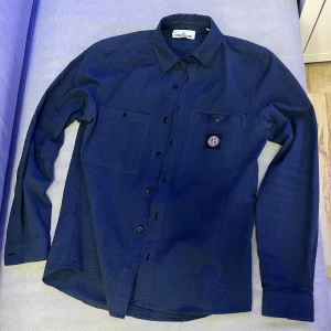 Stone Island Overshirt - Riktigt fet Stone Island Overshirt, perfekt till höst och vinter. Riktigt bra skick- 8,5/10 men saknar knappen längst ner. Är dock inget som märks