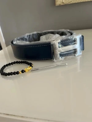 Mörkblått H bälte  - Säljer mitt herrmes bälte 115cm helt nytt. Armband ingår. Hör av er vid frågor och funderingar 