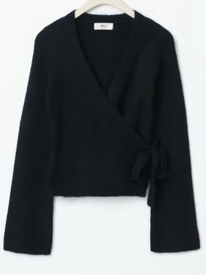 Mörkblå omlottkofta från Gina Tricot - Säljer en mörkblå omlottkofta från Gina Tricot med knyt i sidan. Koftan har lång ärm och är tillverkad i ett mjukt stickat material som känns skönt mot huden. Perfekt för dig som gillar stilrena och enkla plagg med en twist. Original pris 400