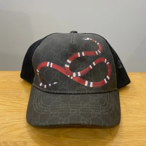 Keps med orm och GG-mönster - Oanvänd. Storlek L - 59 cm. 